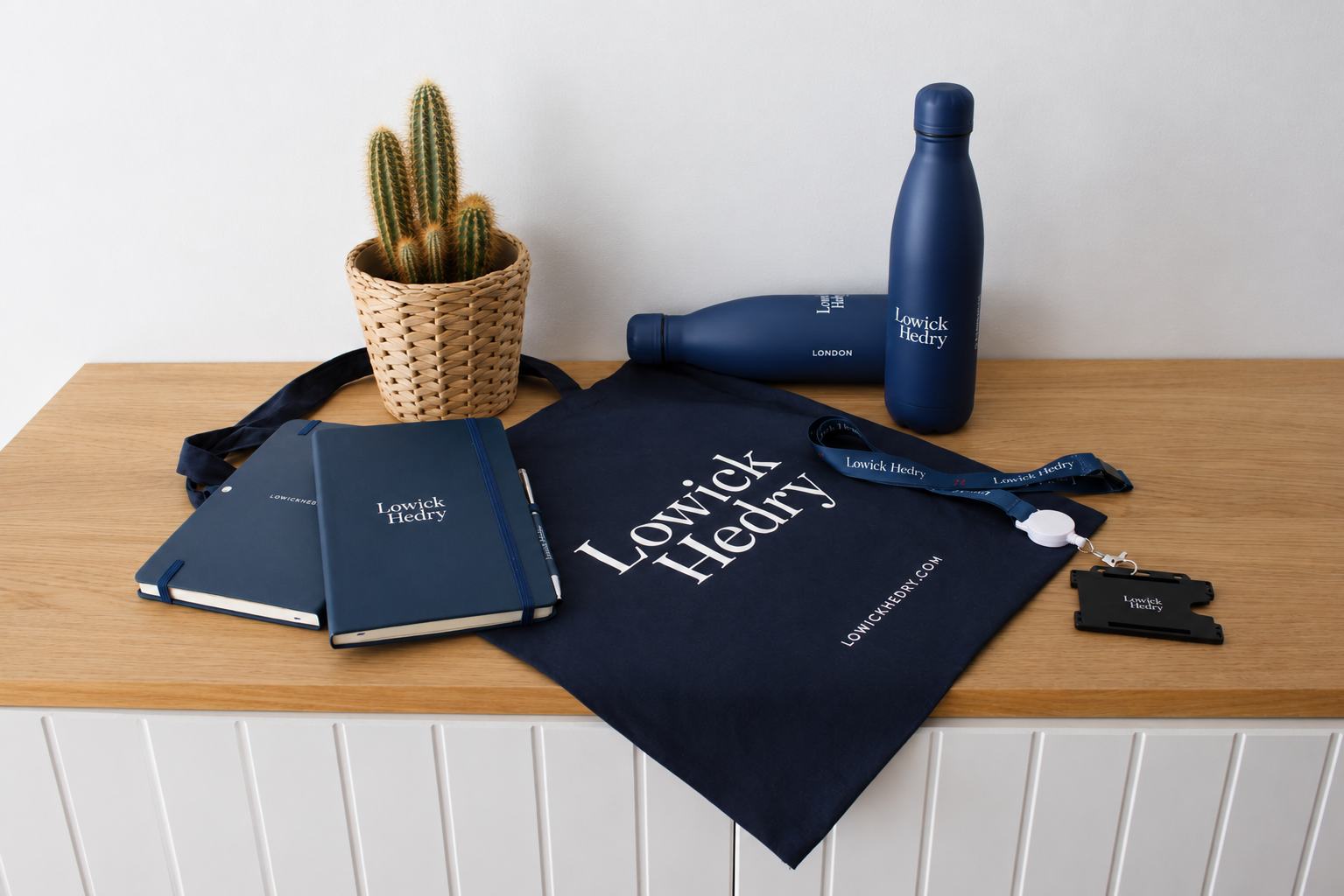 Lowick Hedry branded merchandise: notebooks, tote bag, water bottles and lanyards